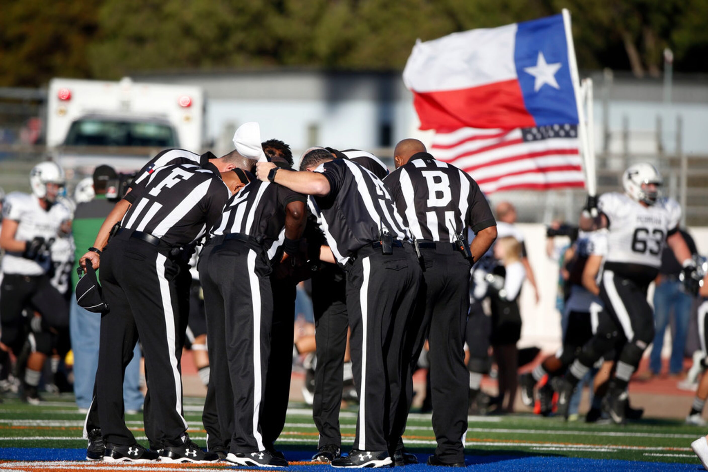 Referees pray at mid-field prior to the Class 6A Division I area-round playoff game between...