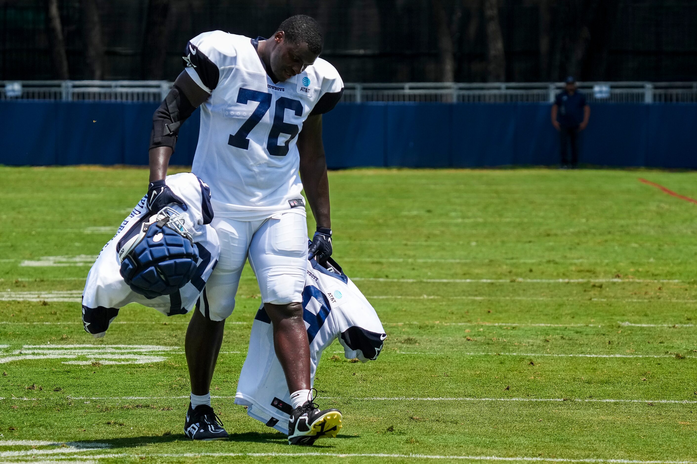 Dallas Cowboys offensive lineman Asim Richards (76) carries the pads of fellow offensive...