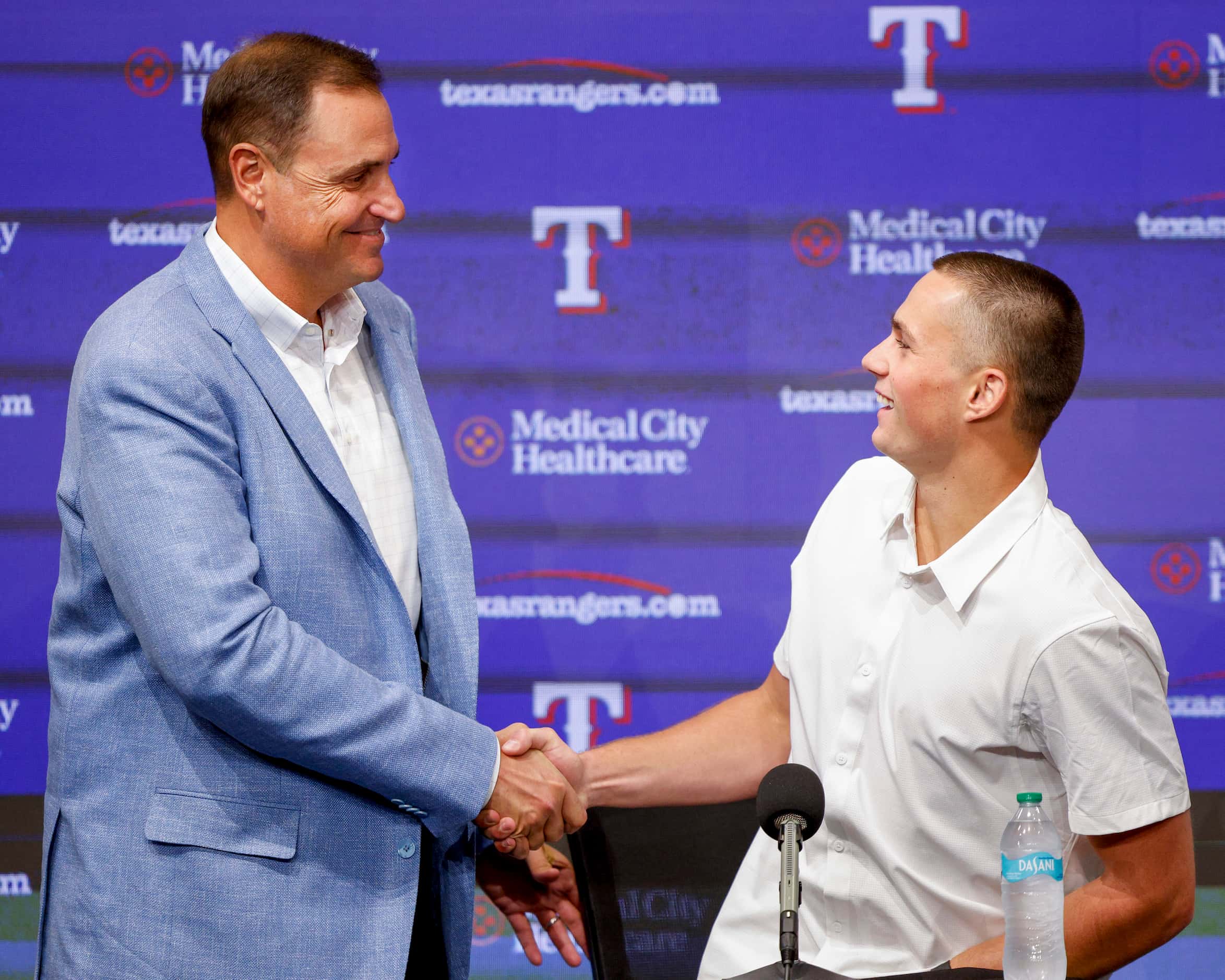 Texas Rangers general manager Chris Young (left) shakes hands with first-round pick Malcolm...