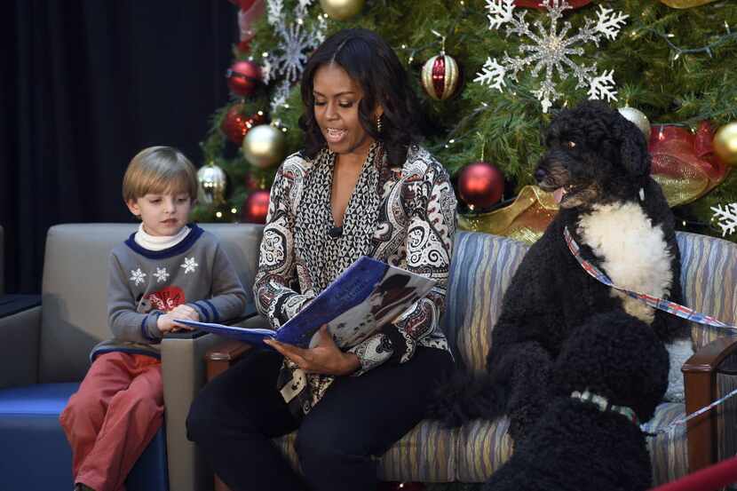 First lady Michelle Obama, sitting with Stephen Orzechowski, 5, left, and Bo Obama, right,...