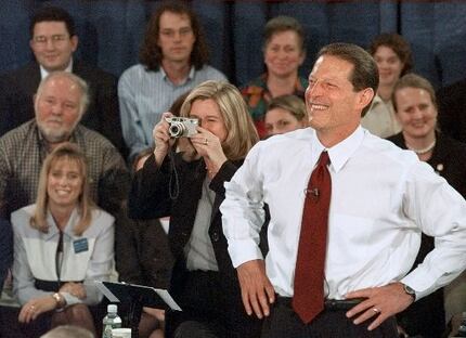 Vice President Al Gore laughs while talking with a voter as his wife, Tipper Gore, snaps a...