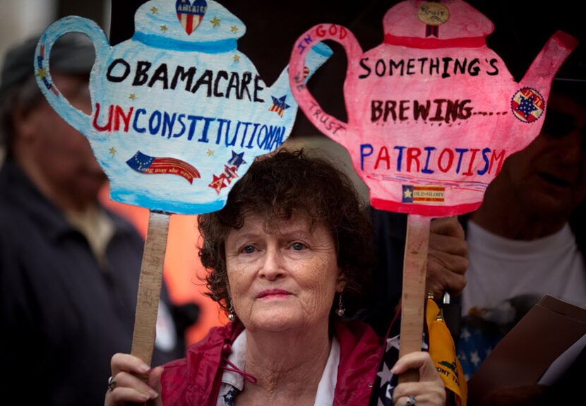 Carlene Cahill of Petersburg, Va., holds up a set of signs she made during a tea party "Road...