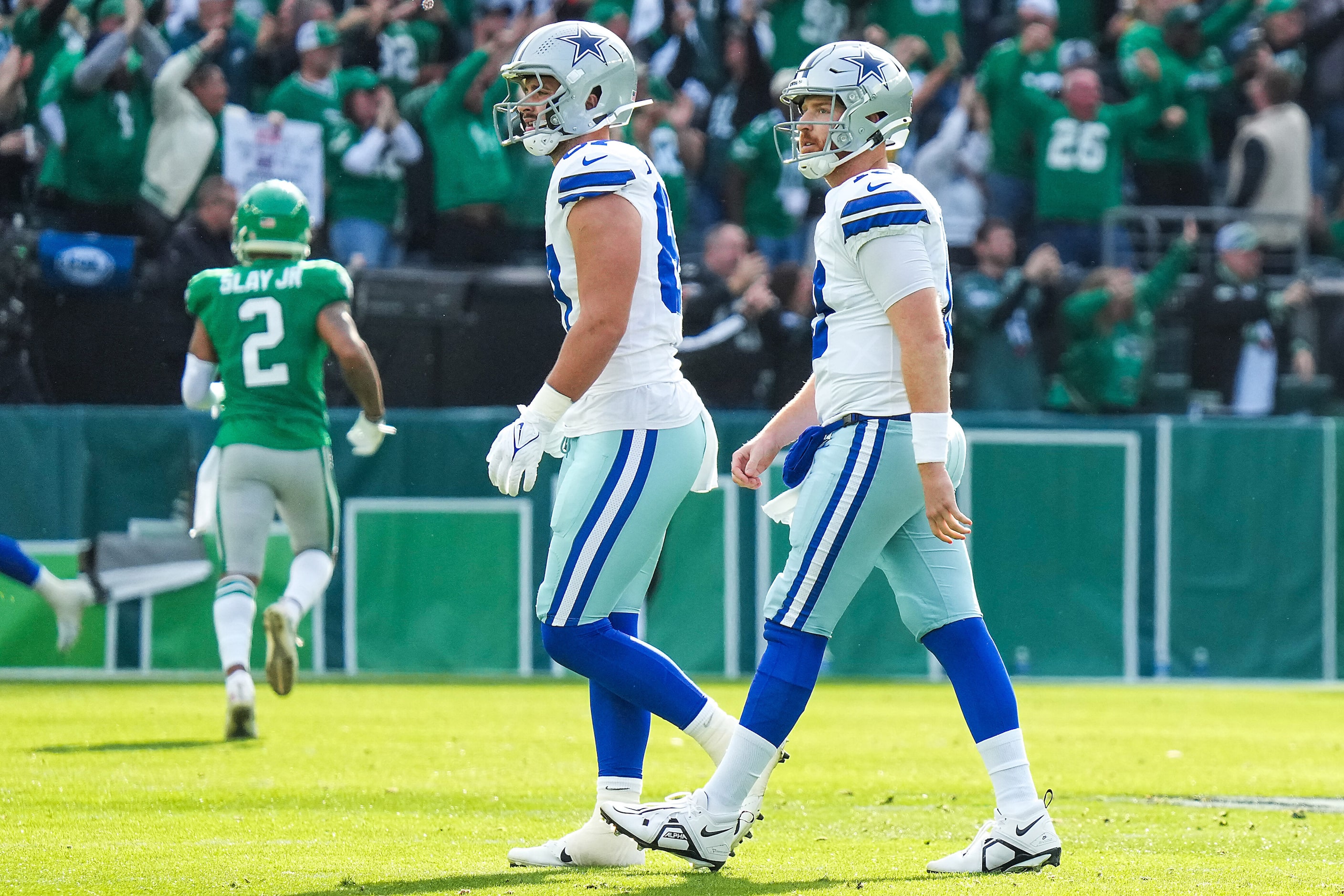 Dallas Cowboys quarterback Cooper Rush (right) walks to the bench with tight end Jake...