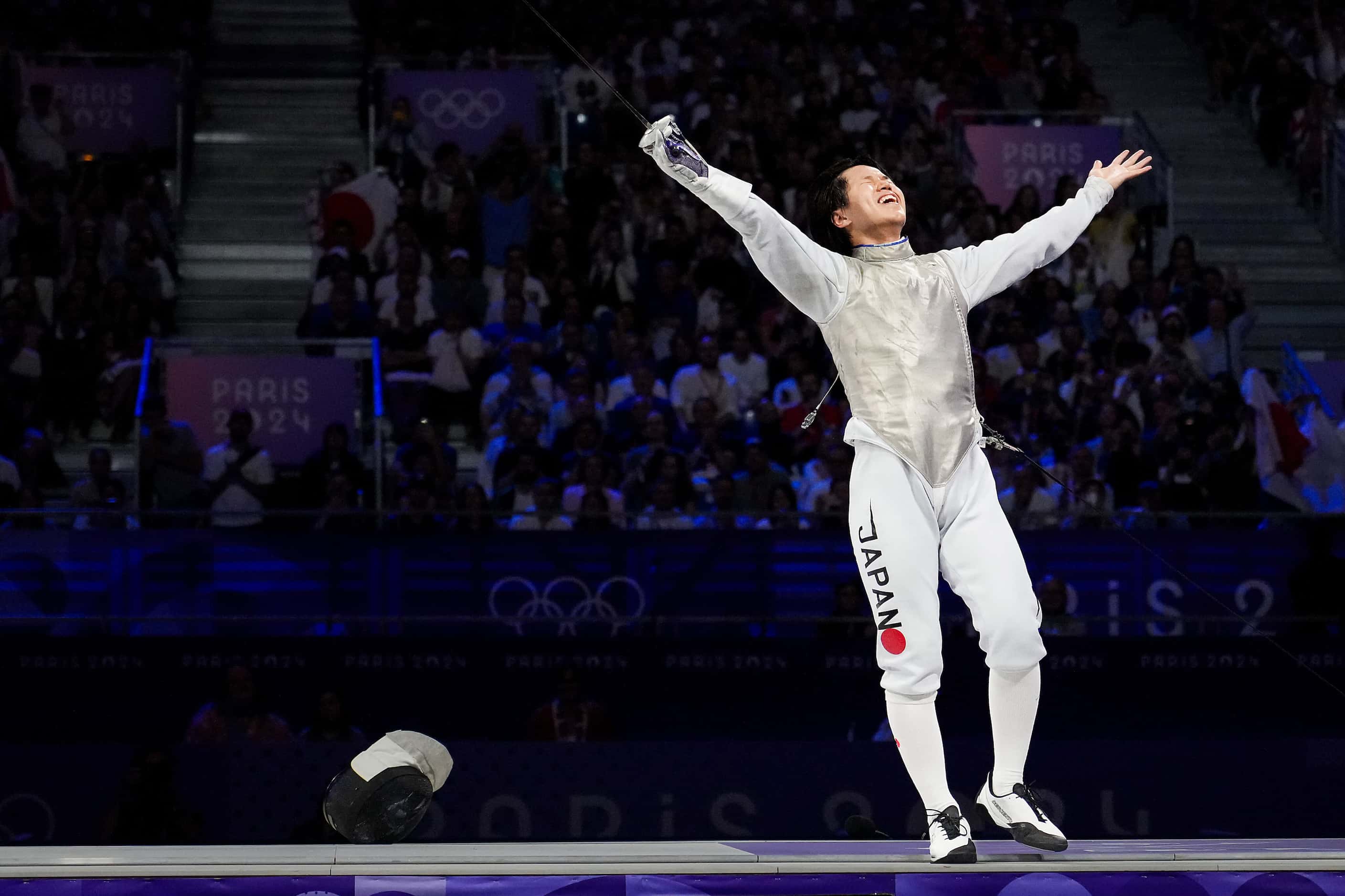 Kazuki Iimura of Japan celebrates after a victory over Italy in the men’s foil team gold...