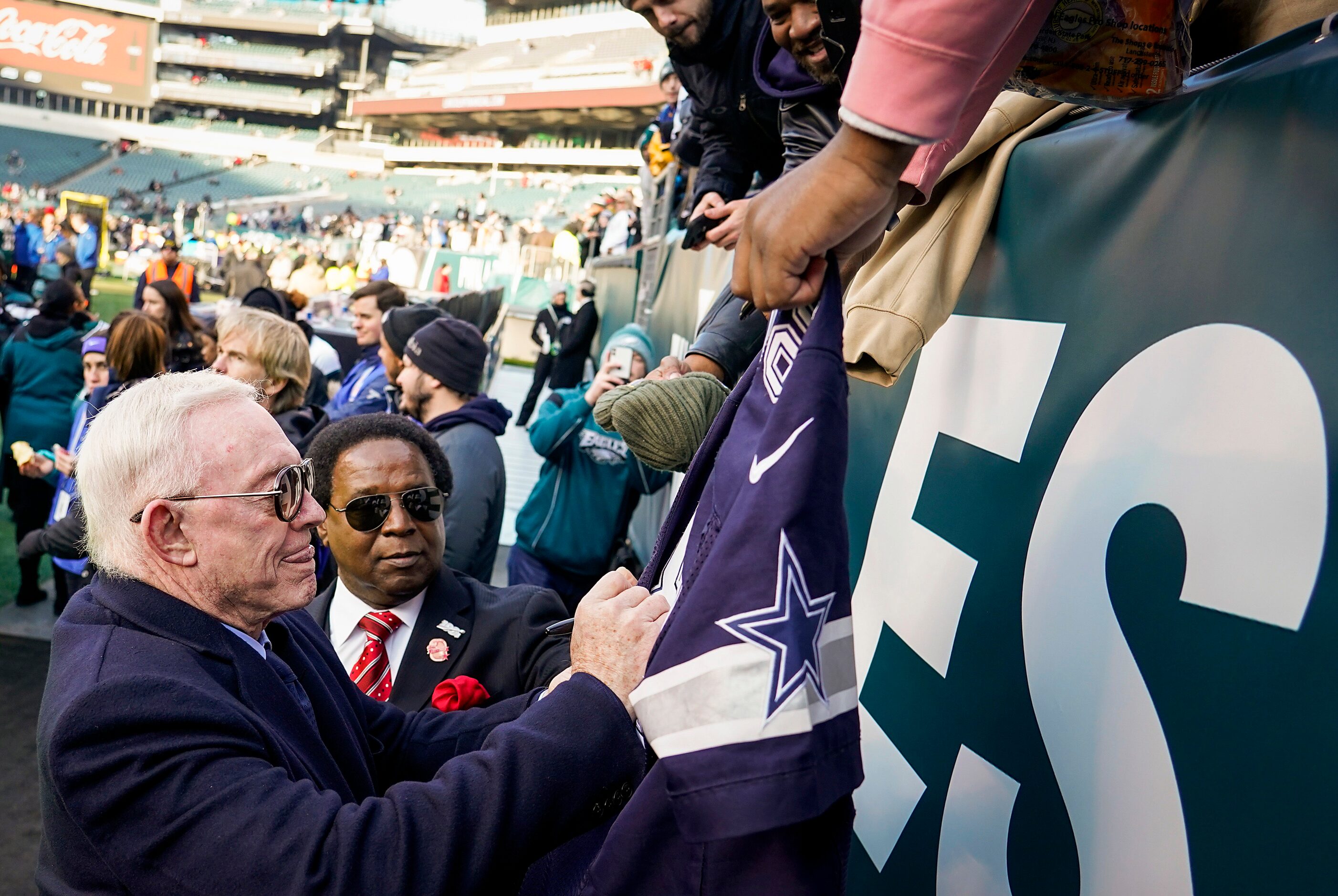 Dallas Cowboys owner Jerry Jones signs autographs for fans before an NFL football game...