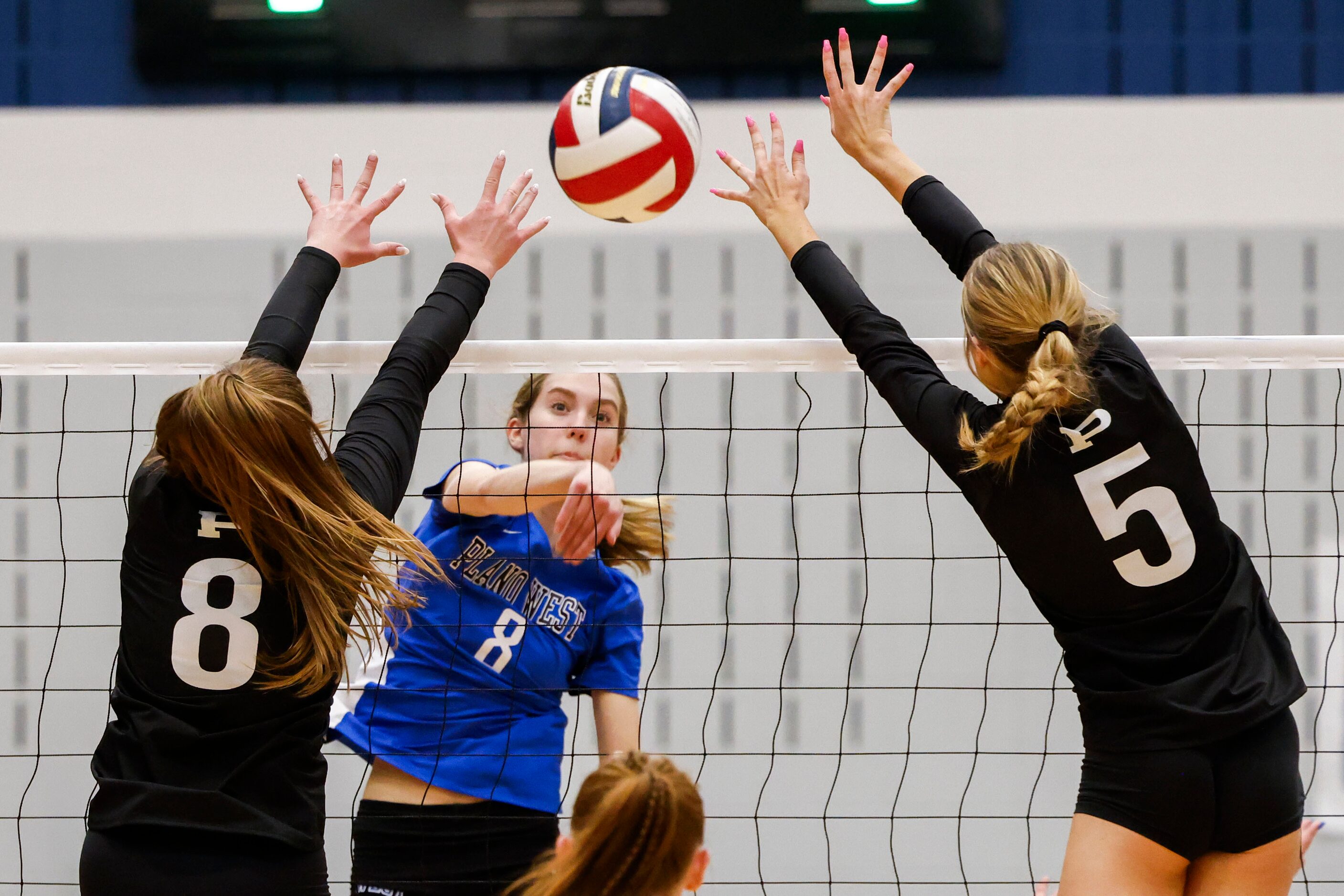 Plano West’s Reese Poerner (8) spikes the ball against Prosper high’s Reese Renfrow (left)...