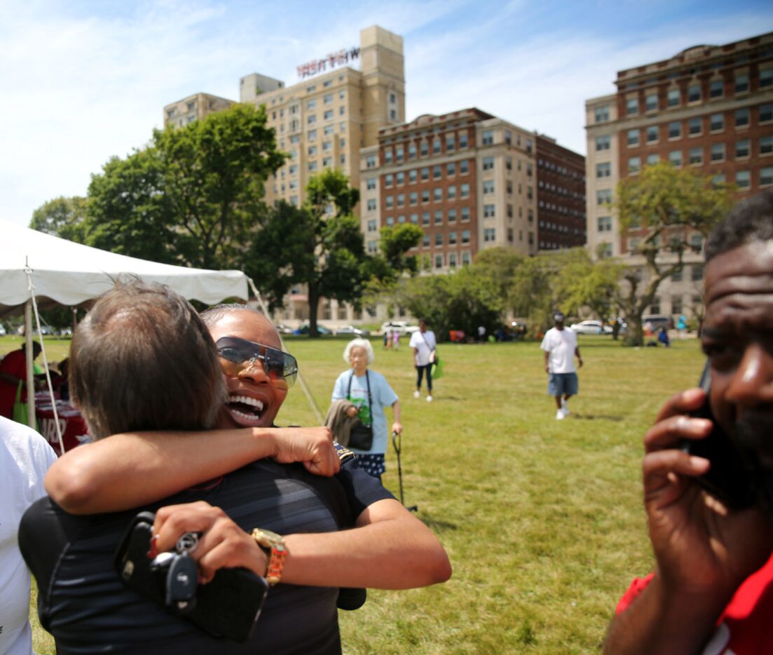 Hall (left, facing camera) hugs Jesse Gonzales, a community liaison for the Detroit Police...