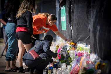 Stacey Sarmiento places flowers at a memorial in Houston on Sunday, Nov. 7, 2021 in memory...