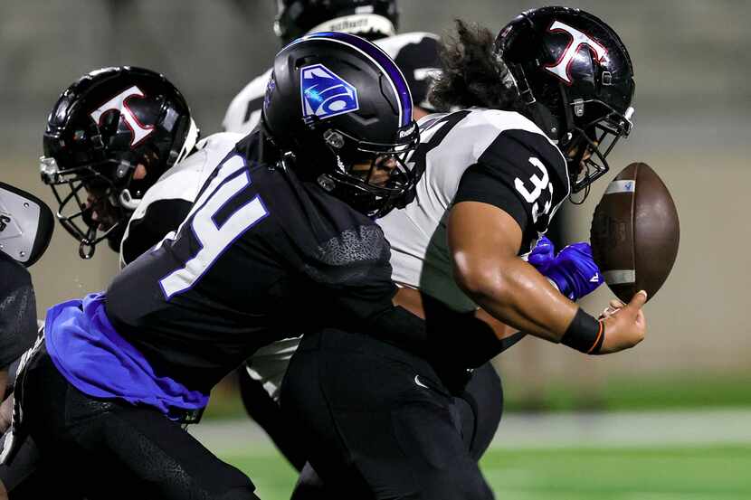 Euless Trinity running back Buddy Leota (33) gets the ball stripped by North Crowley...