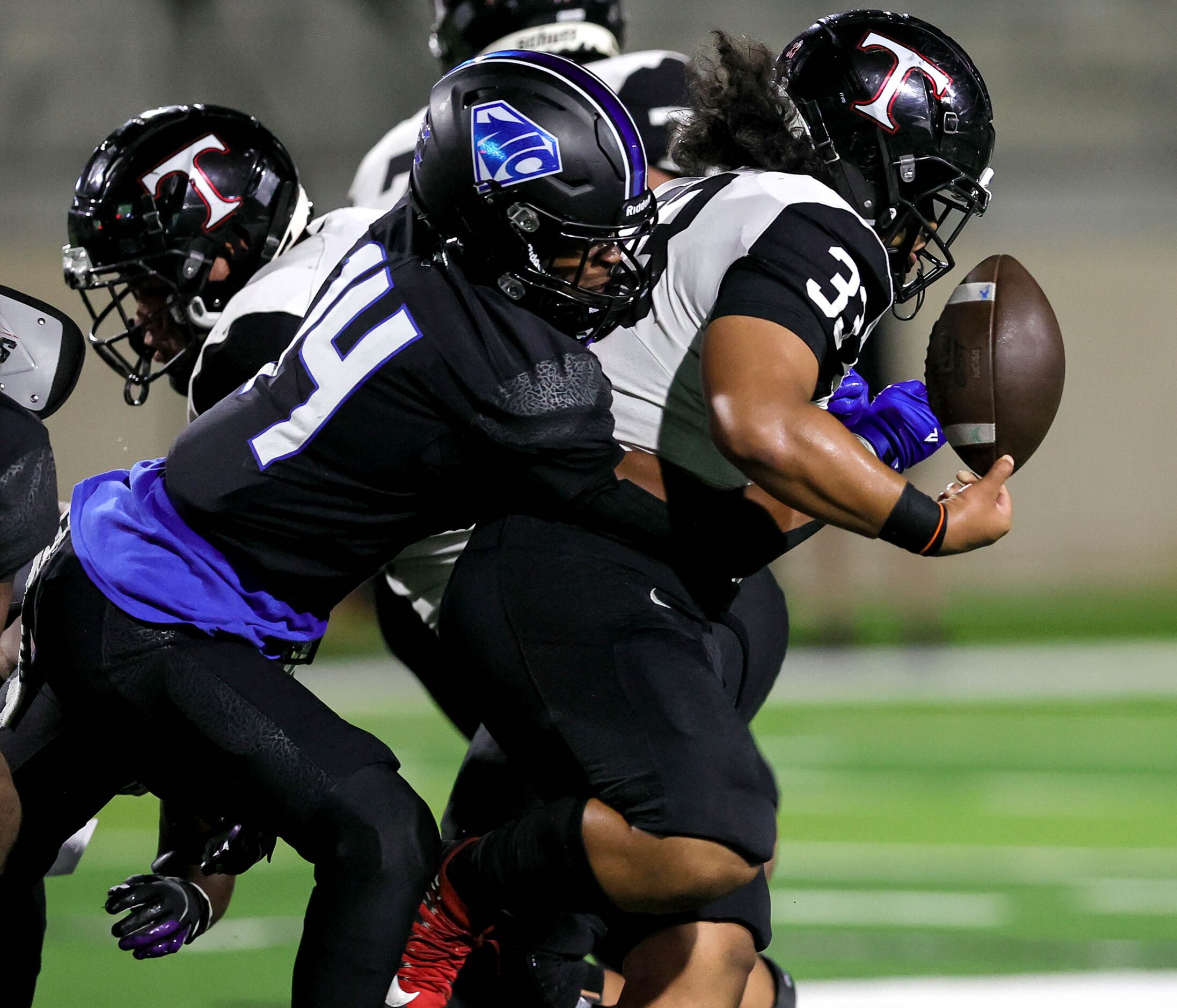 Euless Trinity running back Buddy Leota (33) gets the ball stripped by North Crowley...