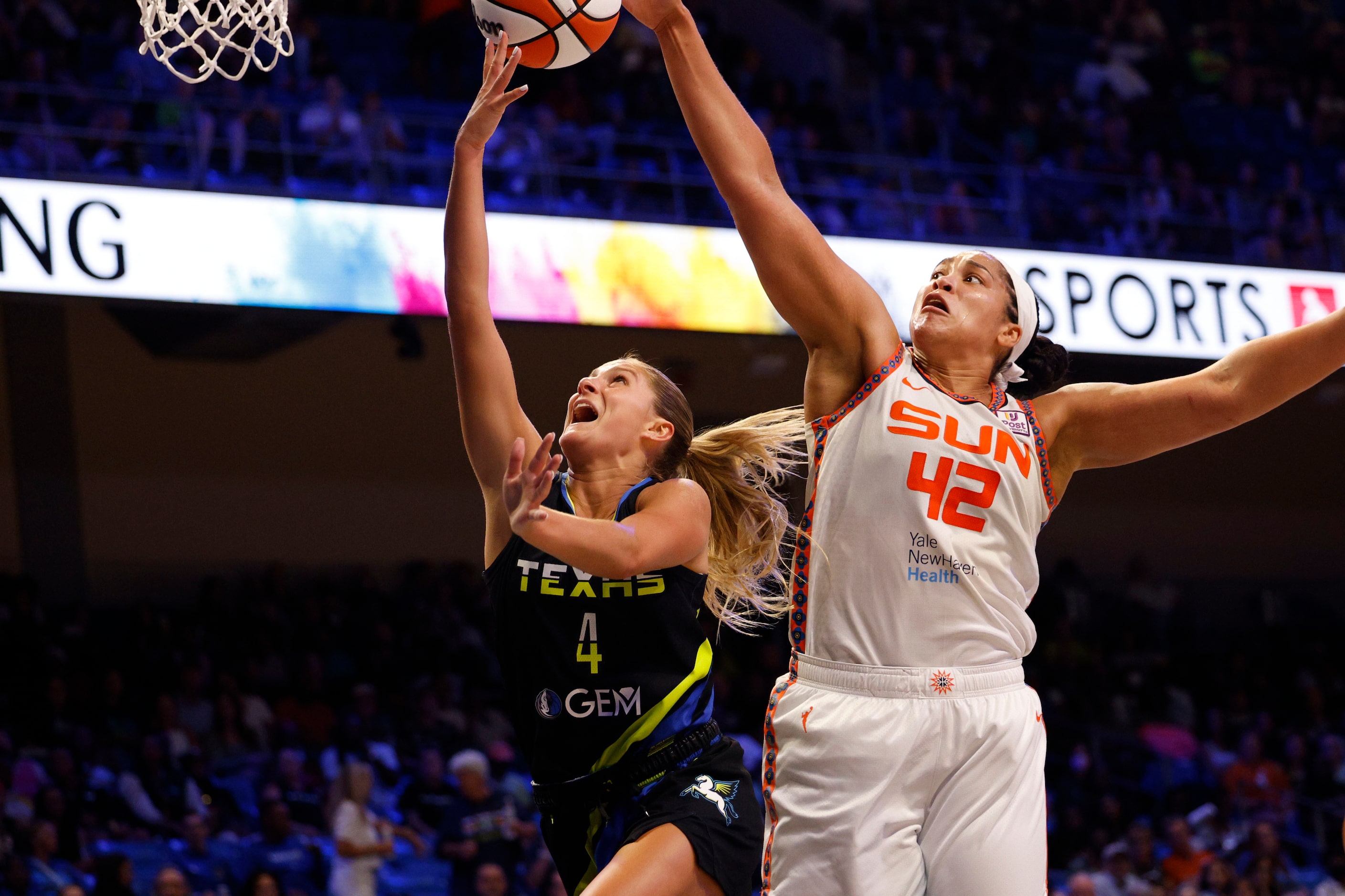 Dallas Wings guard Jacy Sheldon (4) tries to shoot as Connecticut Sun forward Brionna Jones...