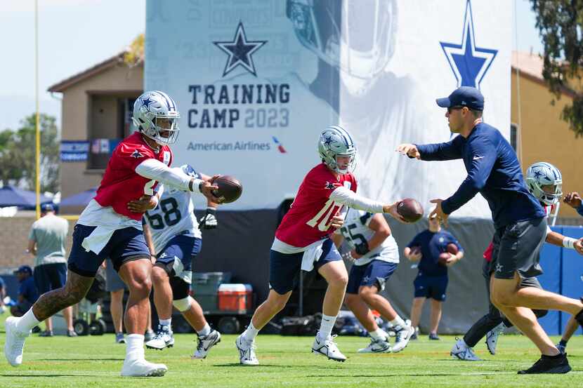 Dallas Cowboys quarterback Dak Prescott (4) and quarterback Cooper Rush (10) hand the ball...