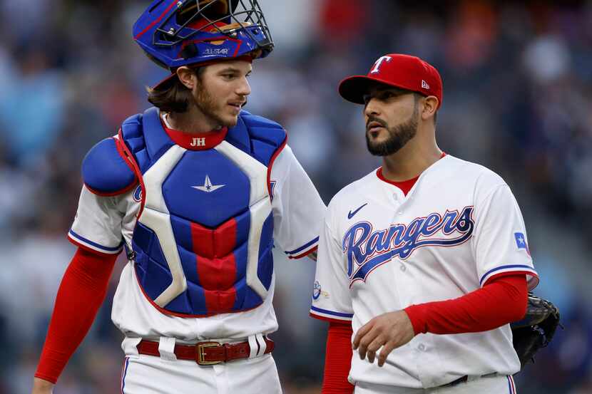 Texas Rangers starting pitcher Martin Perez (right) talks with catcher Jonah Heim (28)...