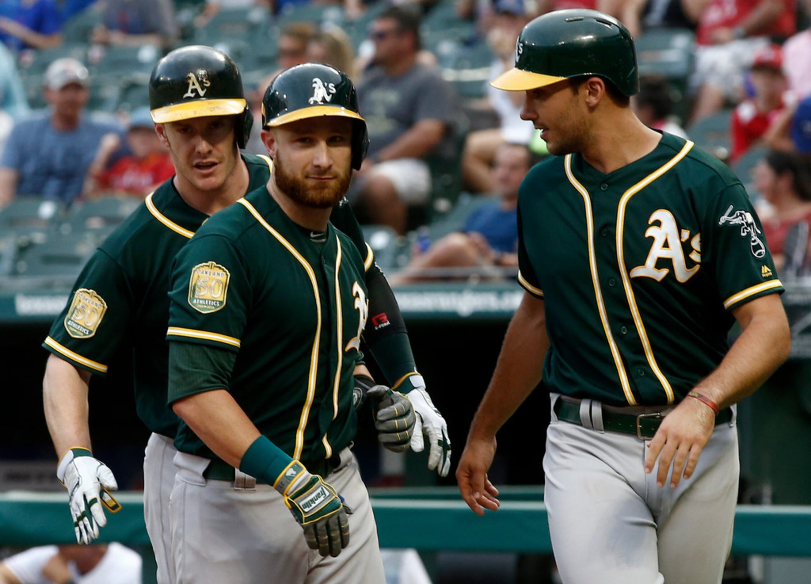 Oakland Athletics Jonathan Lucroy, center, is congratulated by Mark Canha, on right, and...