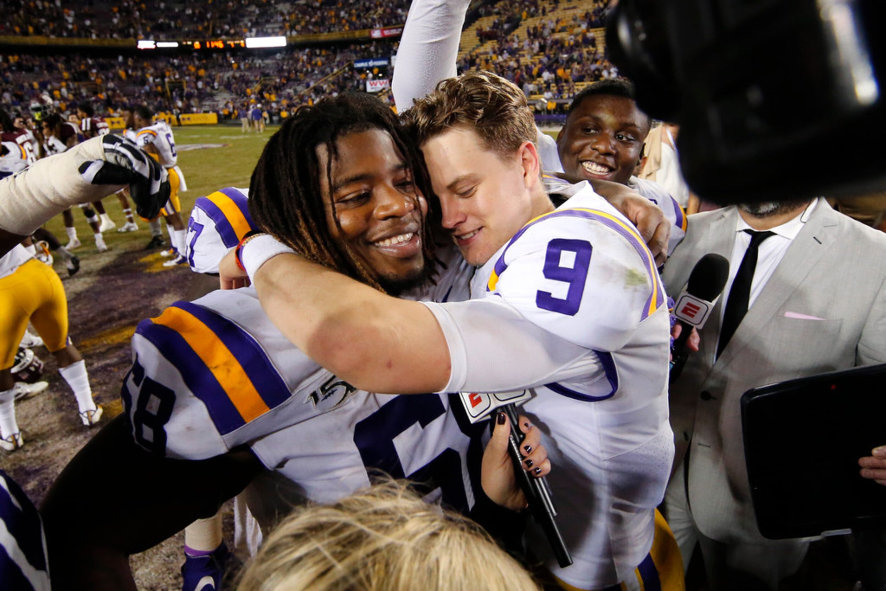 LSU quarterback Joe Burrow (9) hugs guard Damien Lewis after the team's NCAA college...