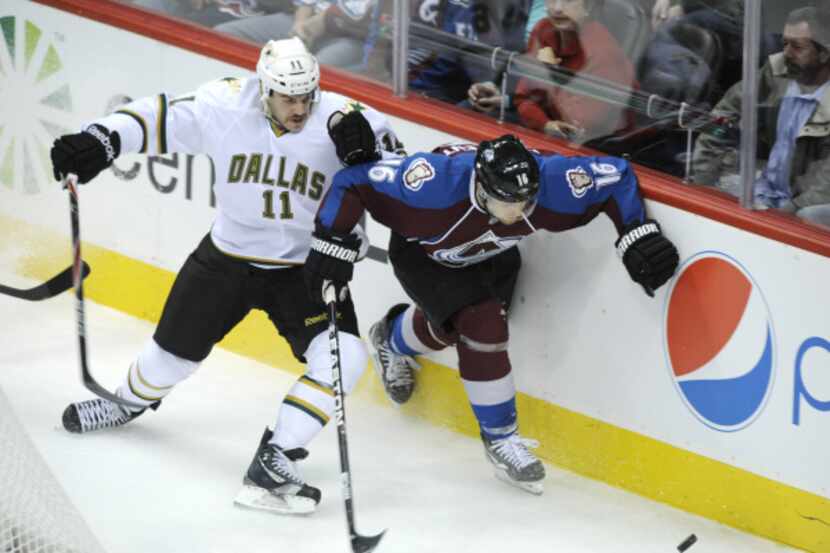 Jake Dowell (11) and Colorado's Jay McClement chase the puck during the second period of the...
