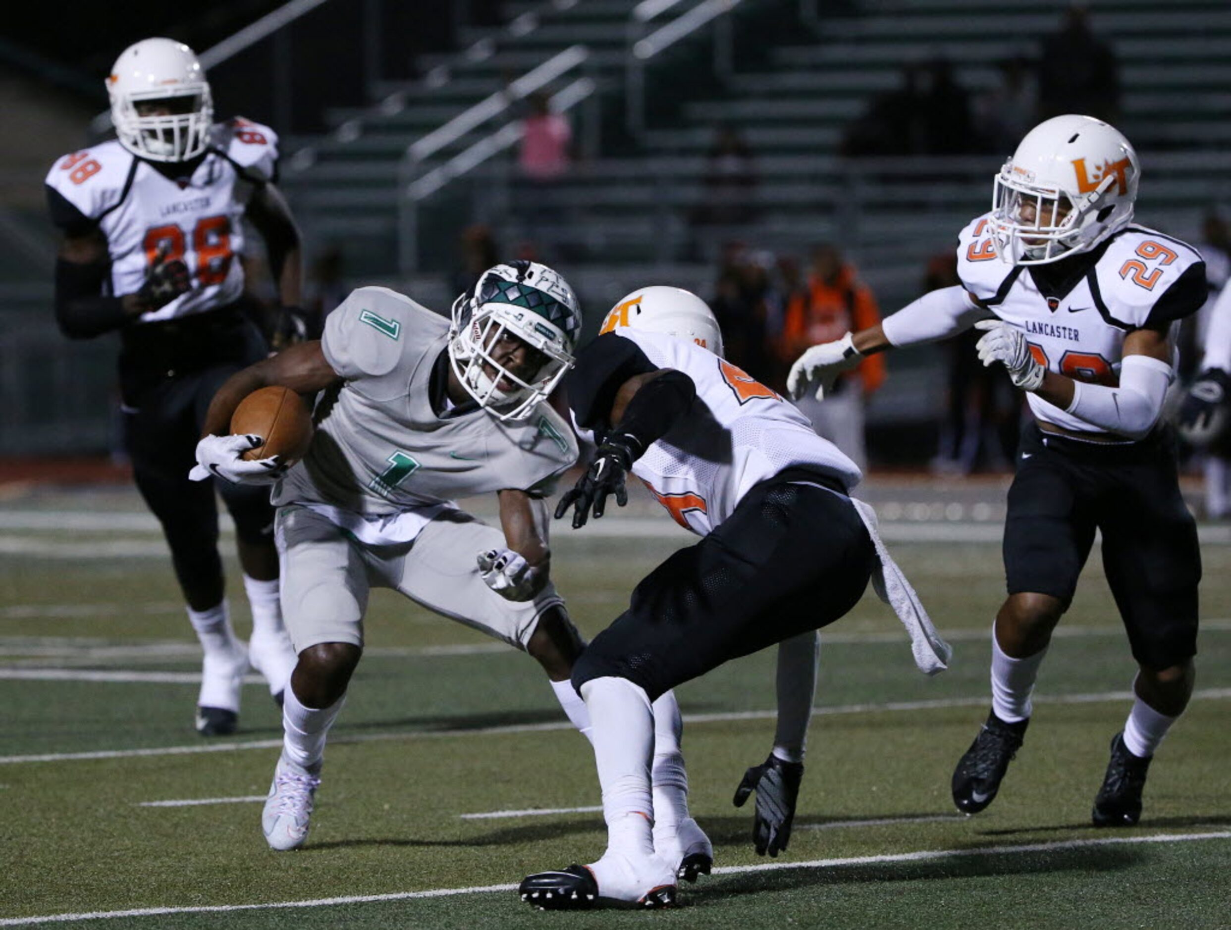 Waxahachie wide receiver Jalen Reagor (1) avoids a tackle by Lancaster defensive back...