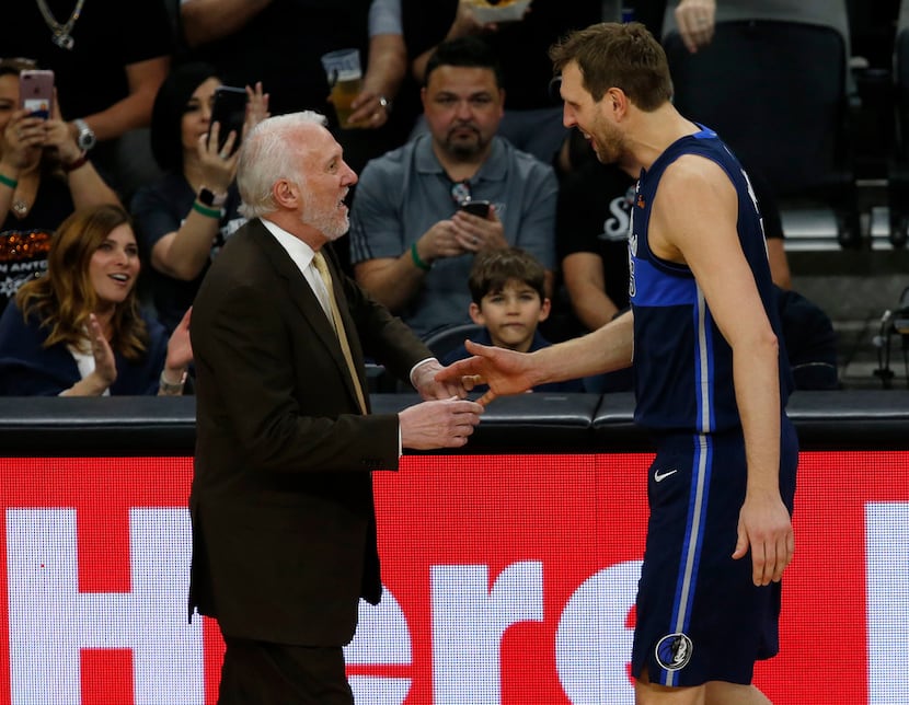 San Antonio Spurs head coach Gregg Popovich talks with Dallas Mavericks forward Dirk...
