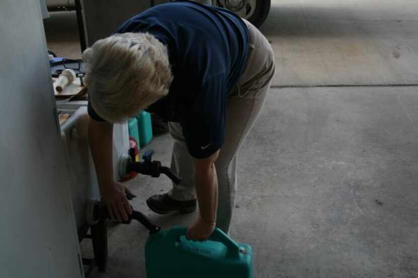 
Coppell Environmental Health specialist Carol Primeaux fills a jug with water. The water is...