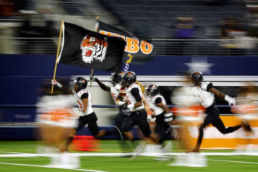 The Lancaster Tigers football team races onto the field to face Frisco Lone Star in the 5A...