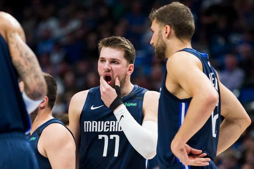 Dallas Mavericks guard Luka Doncic (77) reacts after being hit in the face by the knee of...