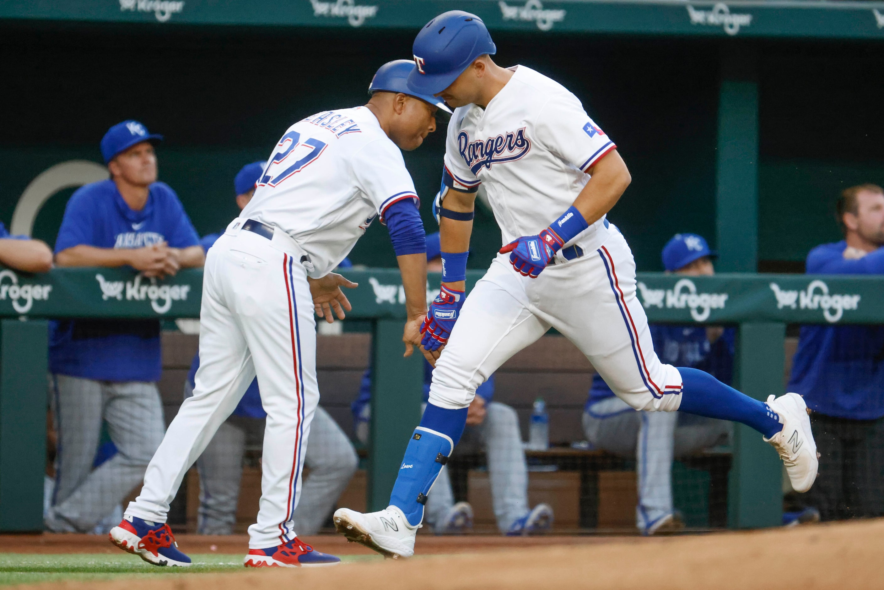 Texas Rangers first baseman Nathaniel Lowe (right) hi fives third base coach Tony Beasley...