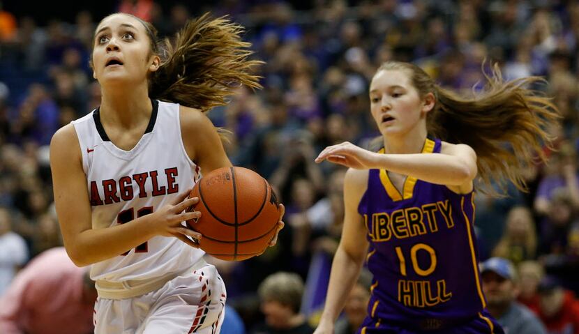 Argyle's Brooklyn Carl (11) drives past Liberty Hill's Bethany McLeod (10) during the class...