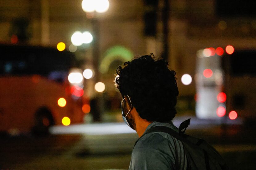 Victor Rodriguez, 26, looks at the buses where migrants arrived, including him, as they...