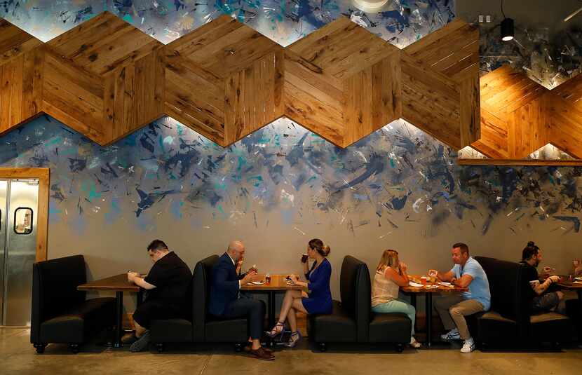 Artist Dan Black painted the art at Barley & Board. The six-sided pieces of wood, which...