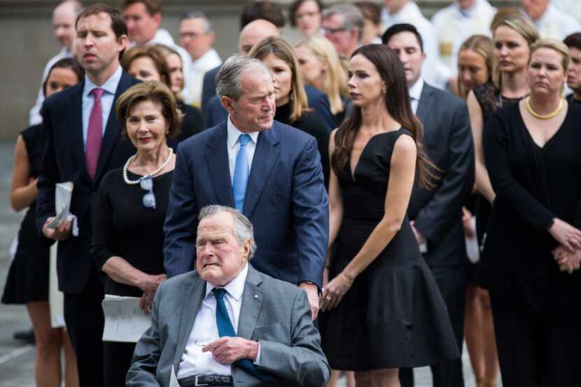 Former President George W. Bush escorts his father, former President George H.W. Bush, out...