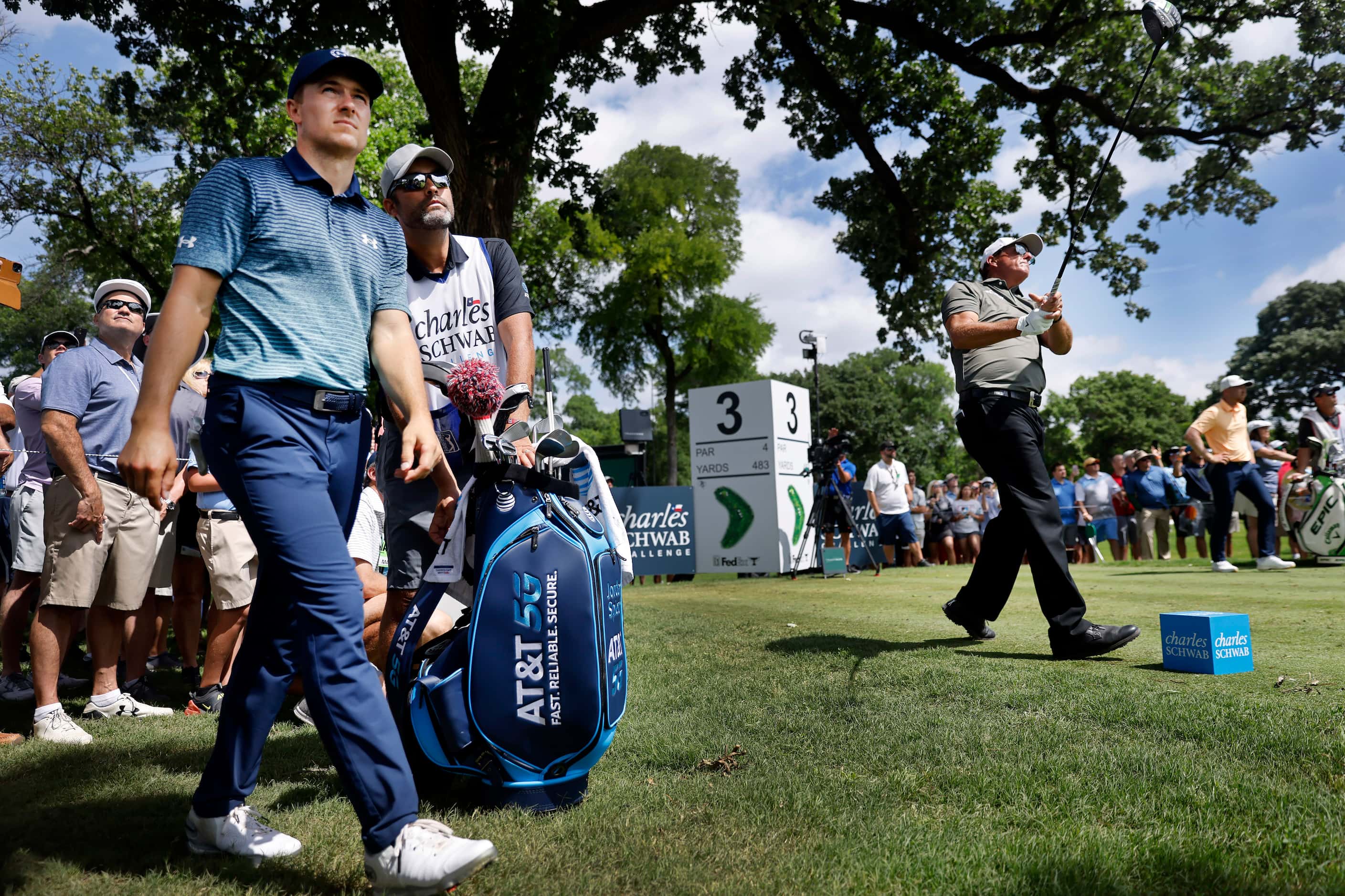 Professional golfer Jordan Spieth (left) watches Phil Mickelson's drive off the No. 3 tee...