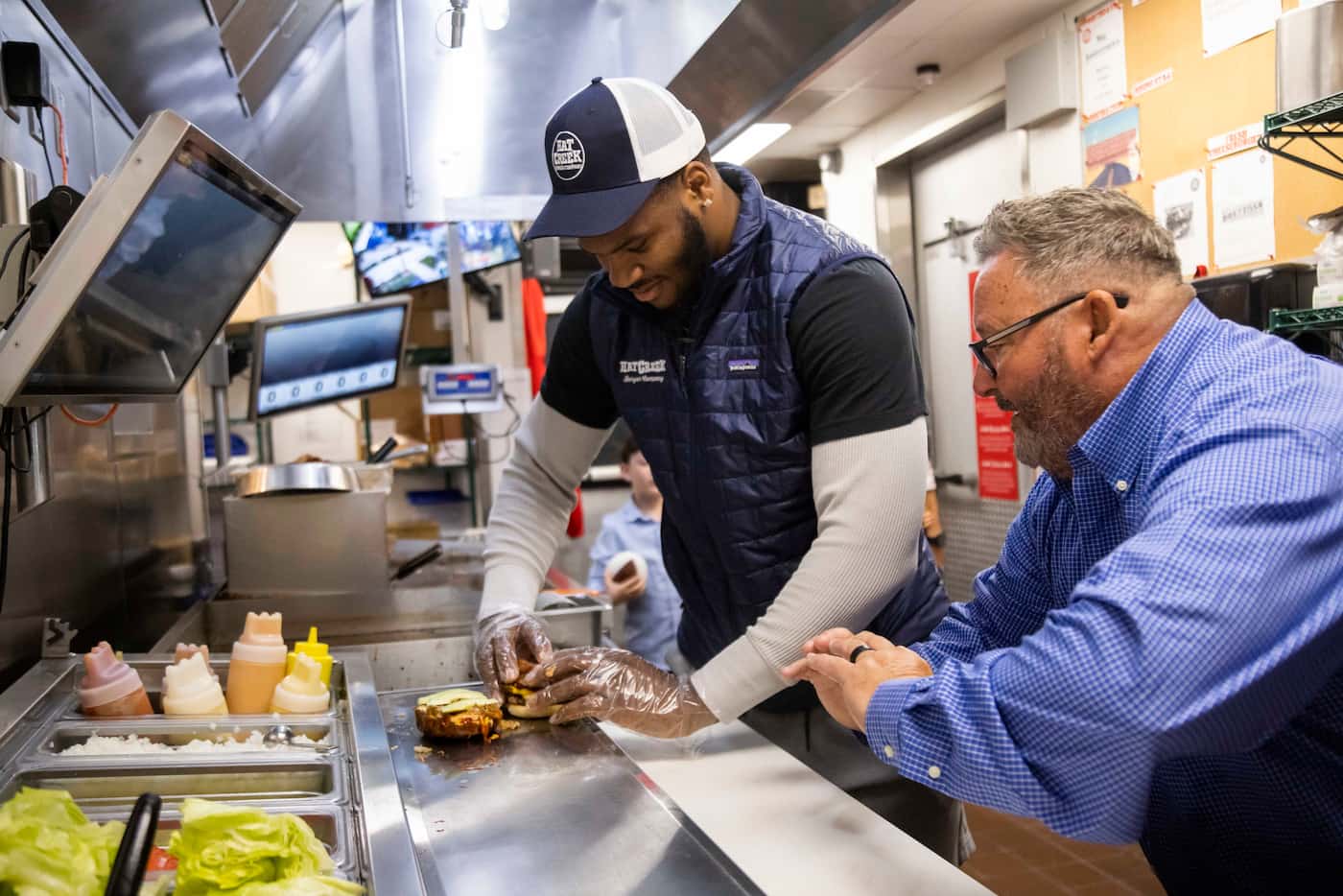 Robert Cooper, district manager for Hat Creek Burger Company, shows Dallas Cowboys...