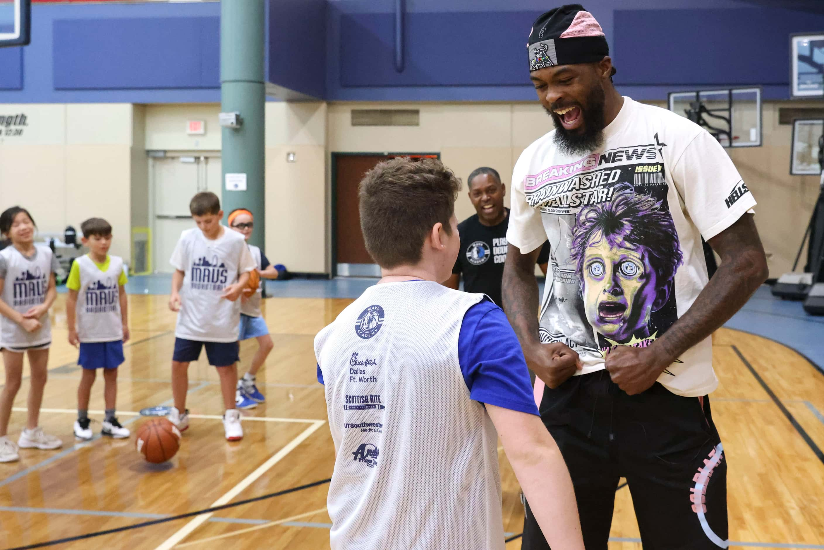 Dallas Mavericks’ Naji Marshall, reacts towards a camper after blocking his shot while...