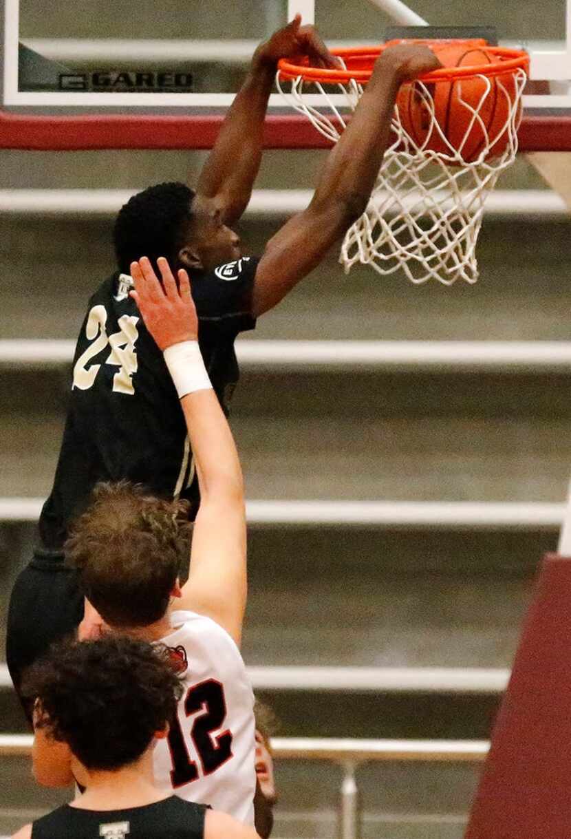 The Colony High School's Bryce Okpoh (24) dunks the ball in front of Colleyvile Heritage...