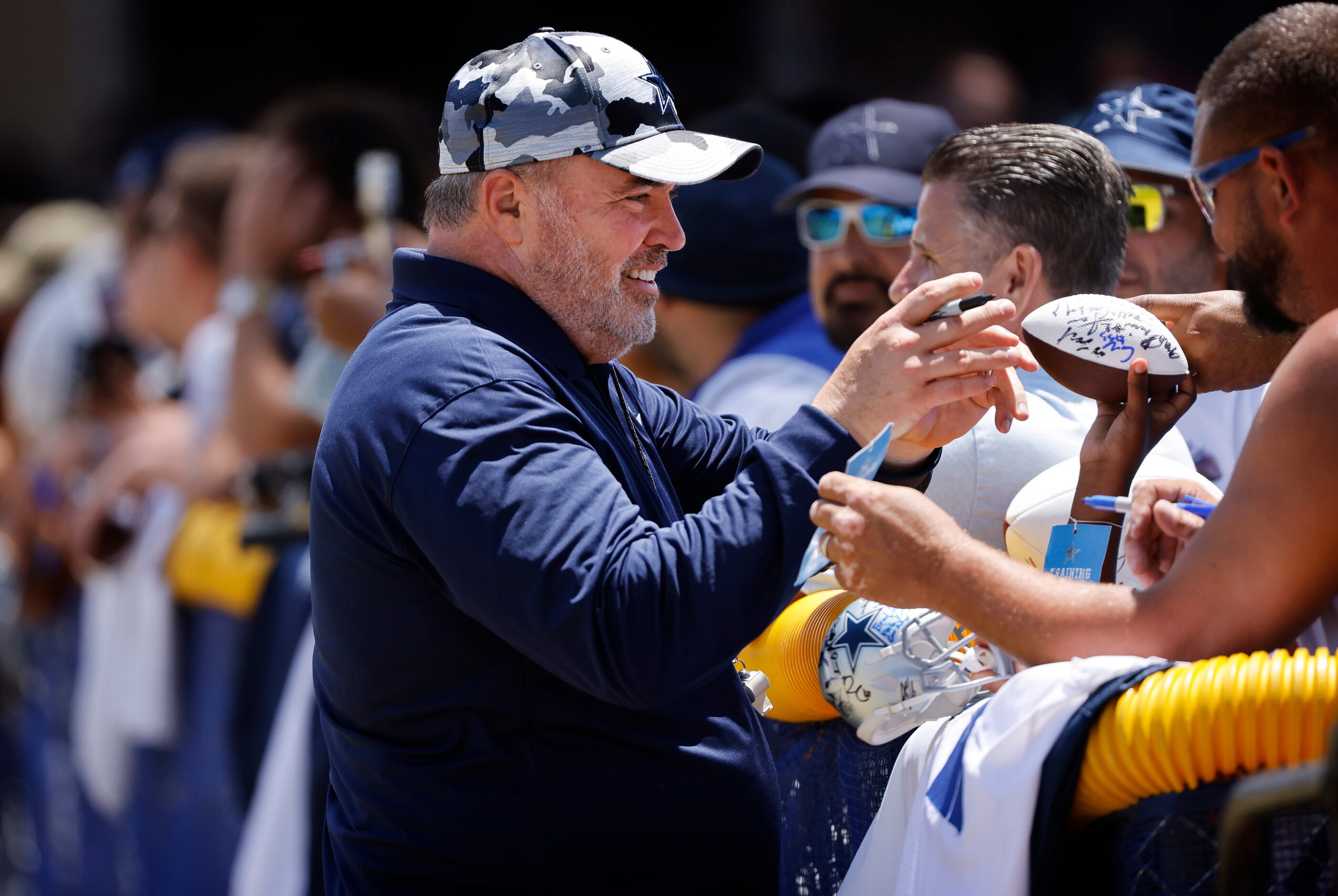 Dallas Cowboys head coach Mike McCarthy signs autographs for fans following training camp...