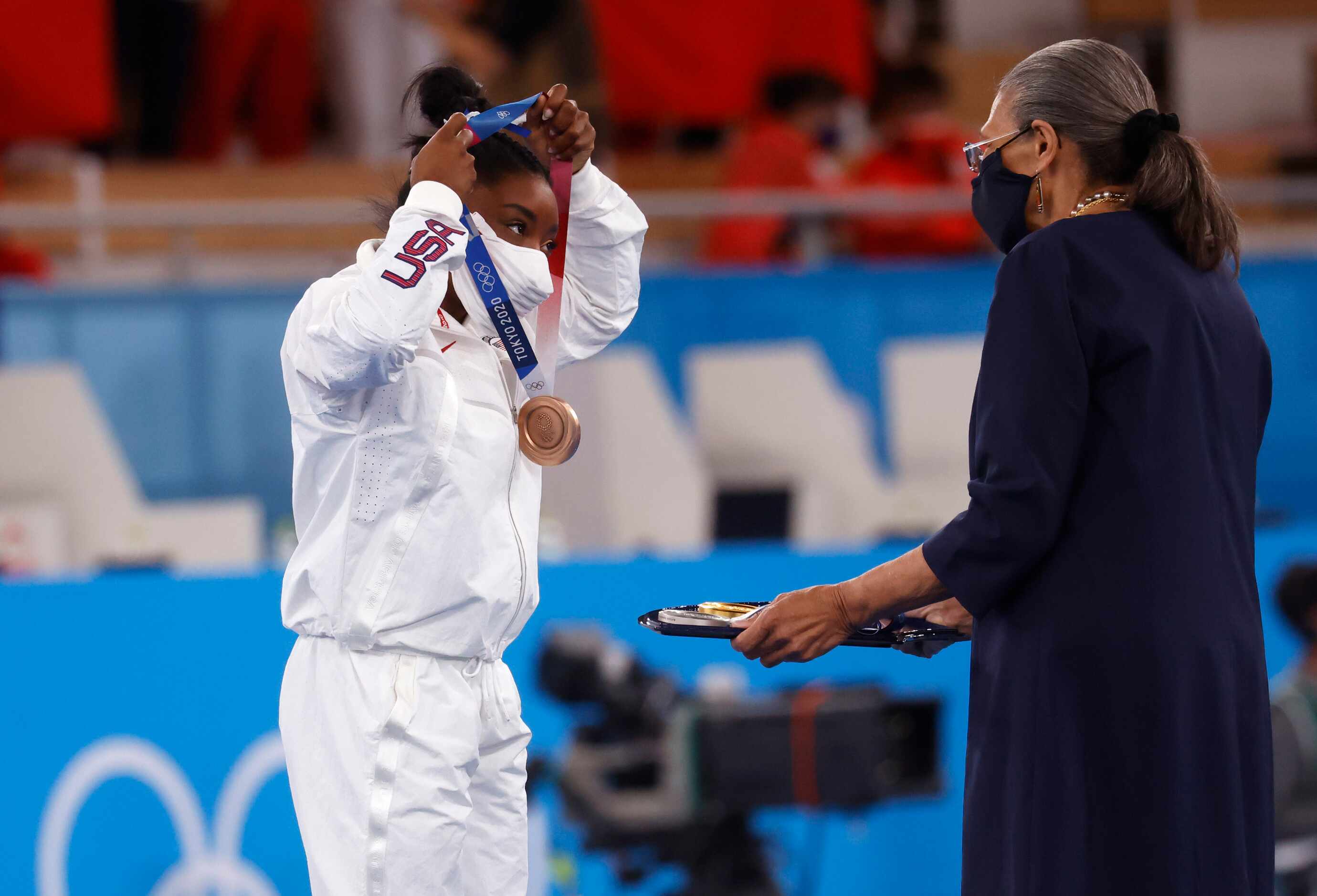 USA’s Simone Biles puts on her bronze medal during the medal ceremony for the women’s...