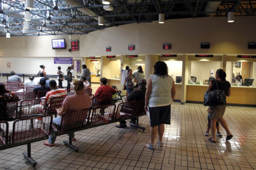 People waited in line to be helped at the Parkland hospital pharmacy as others sat in the...