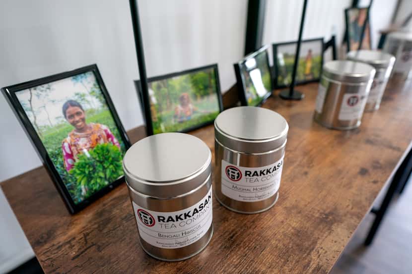 Canisters of Rakkasan Tea sit in front of photos of tea growers from the countries where the...