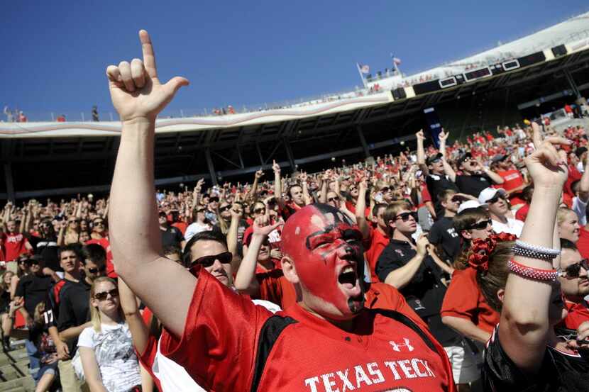 Diehard Texas Tech fan, Scott Gilliland of Lubbock, gets his guns out after a touchdown in...