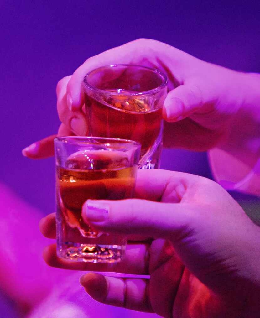 
Audience members clink shot glasses at an 11 p.m. production of Jerry Springer: The Opera...