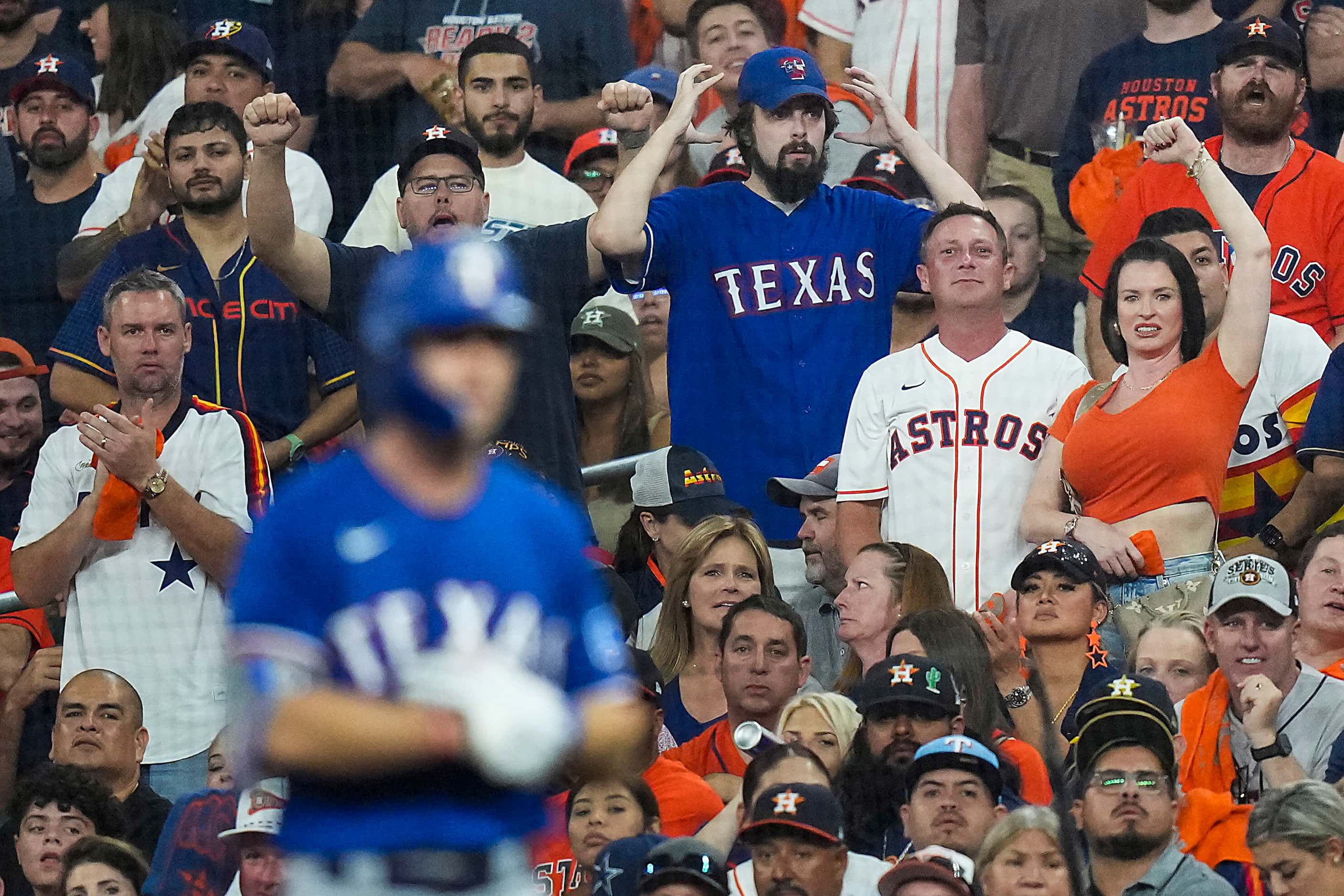 A Texas Rangers fan motions for a replay after Rangers left fielder Evan Carter was called...