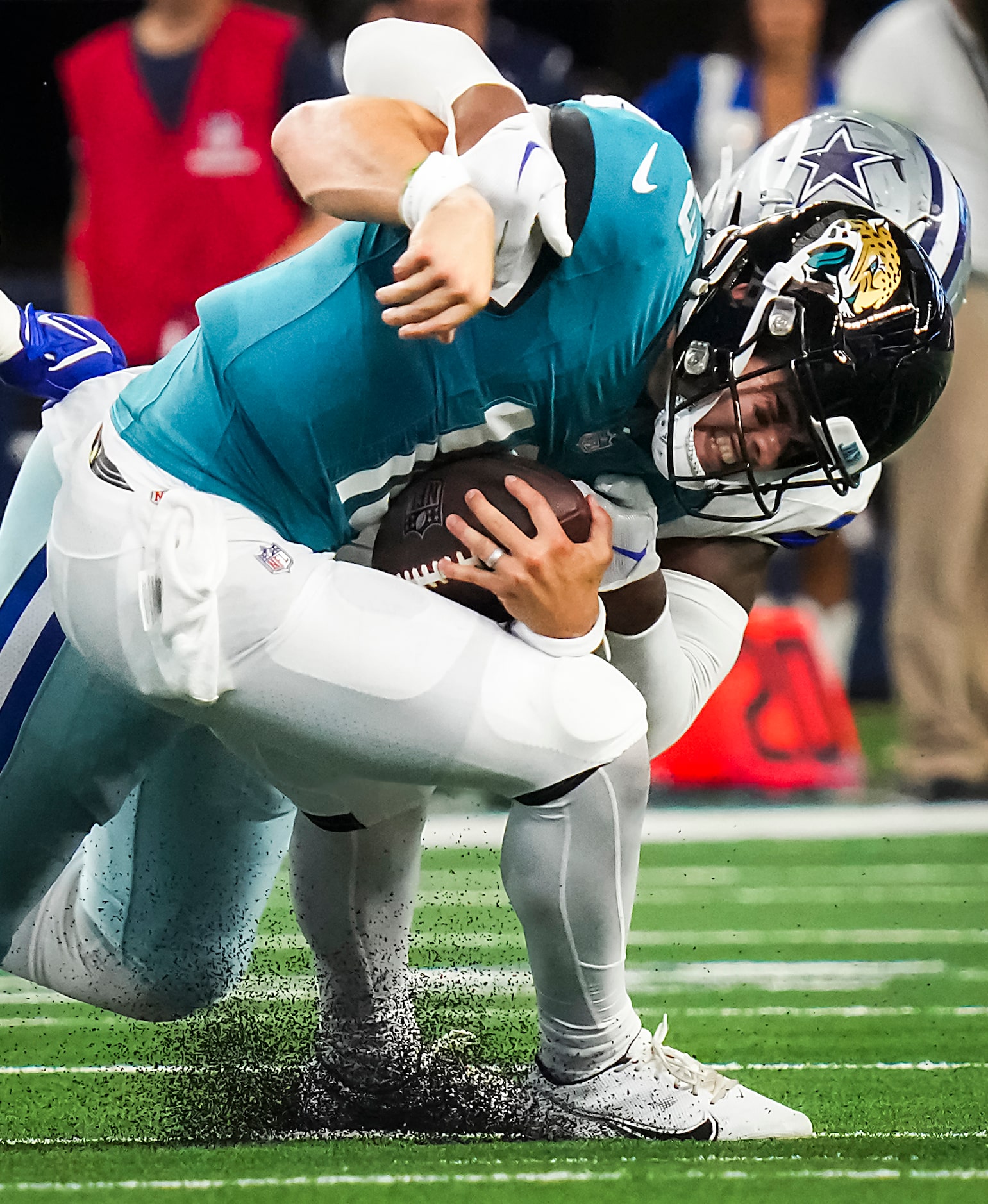 Jacksonville Jaguars quarterback Nathan Rourke (18) slips away from Dallas Cowboys defensive...