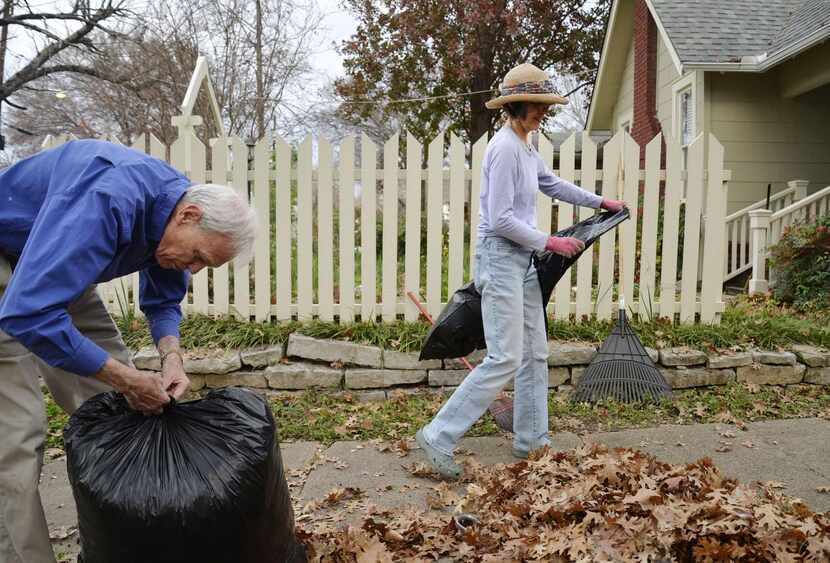 
John Davis of Richardson ties a bag of leaves while his friend Suzanne Lockridge moves to...