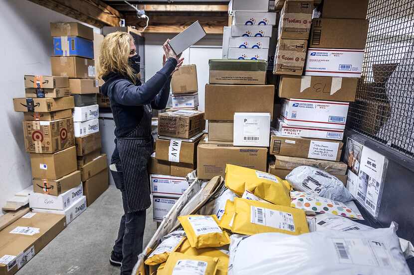 Managing a huge amount of packages, Diana Naramore, owner of Sip and Ship in Seattle, tidies...