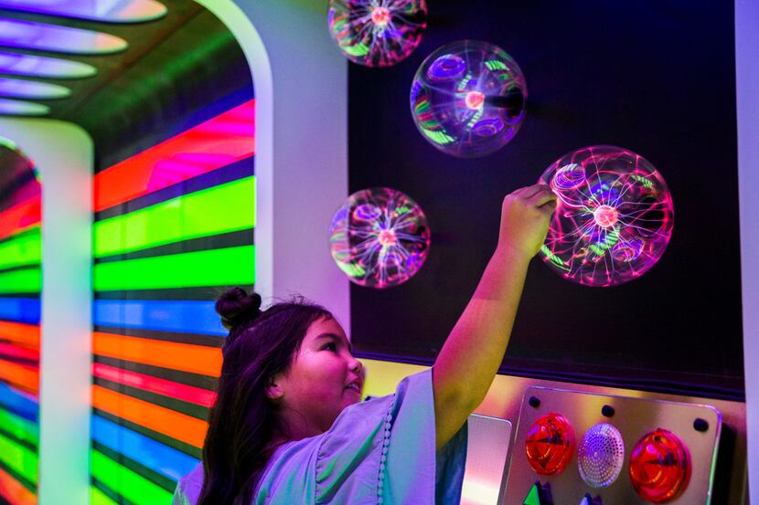 Ellie Colvin, 8, tests the control panel inside Rainbow Rocketship, created by artists Built...