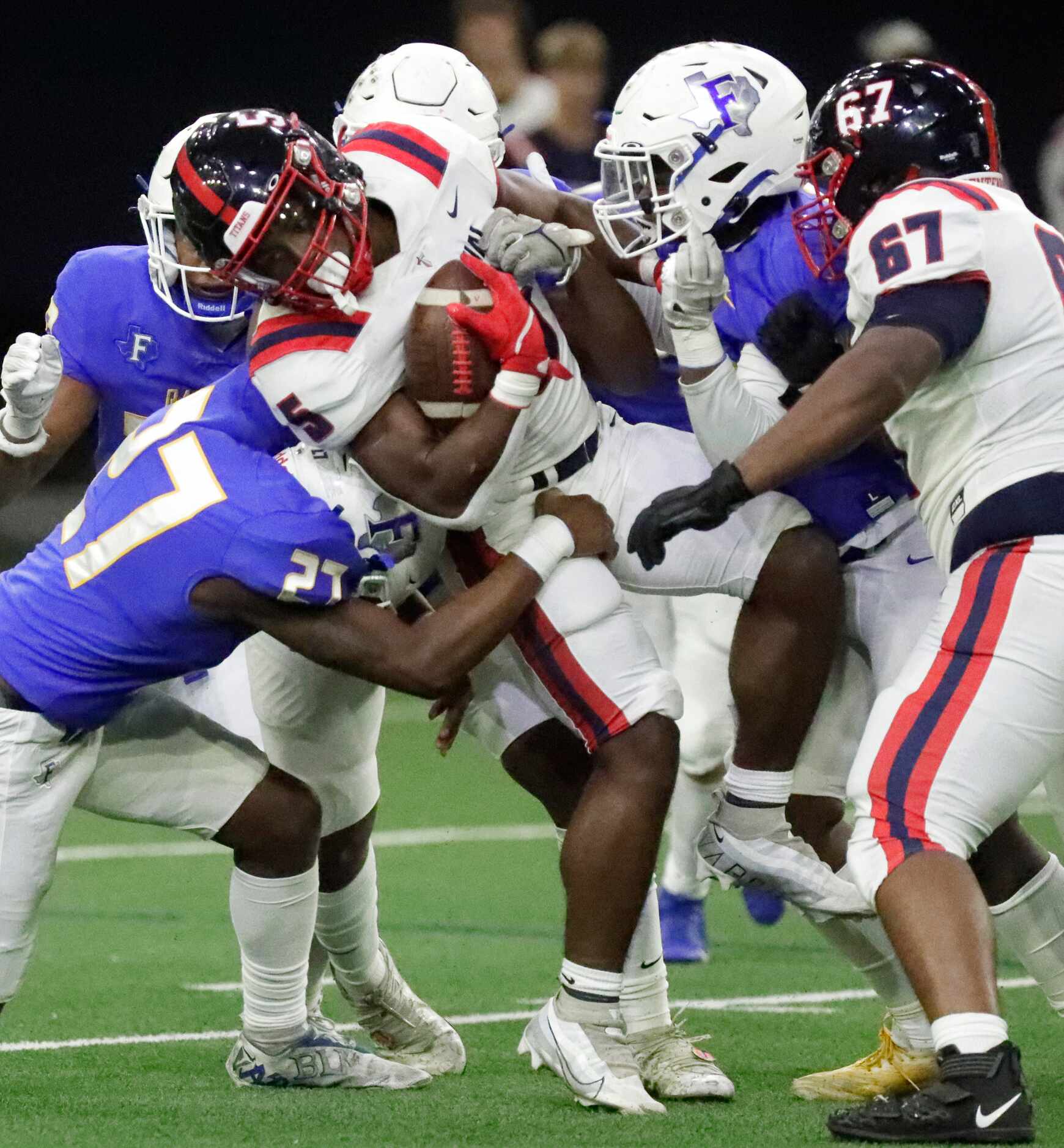 Centennial High School running back Harry Stewart (5) is held up by Frisco High School...