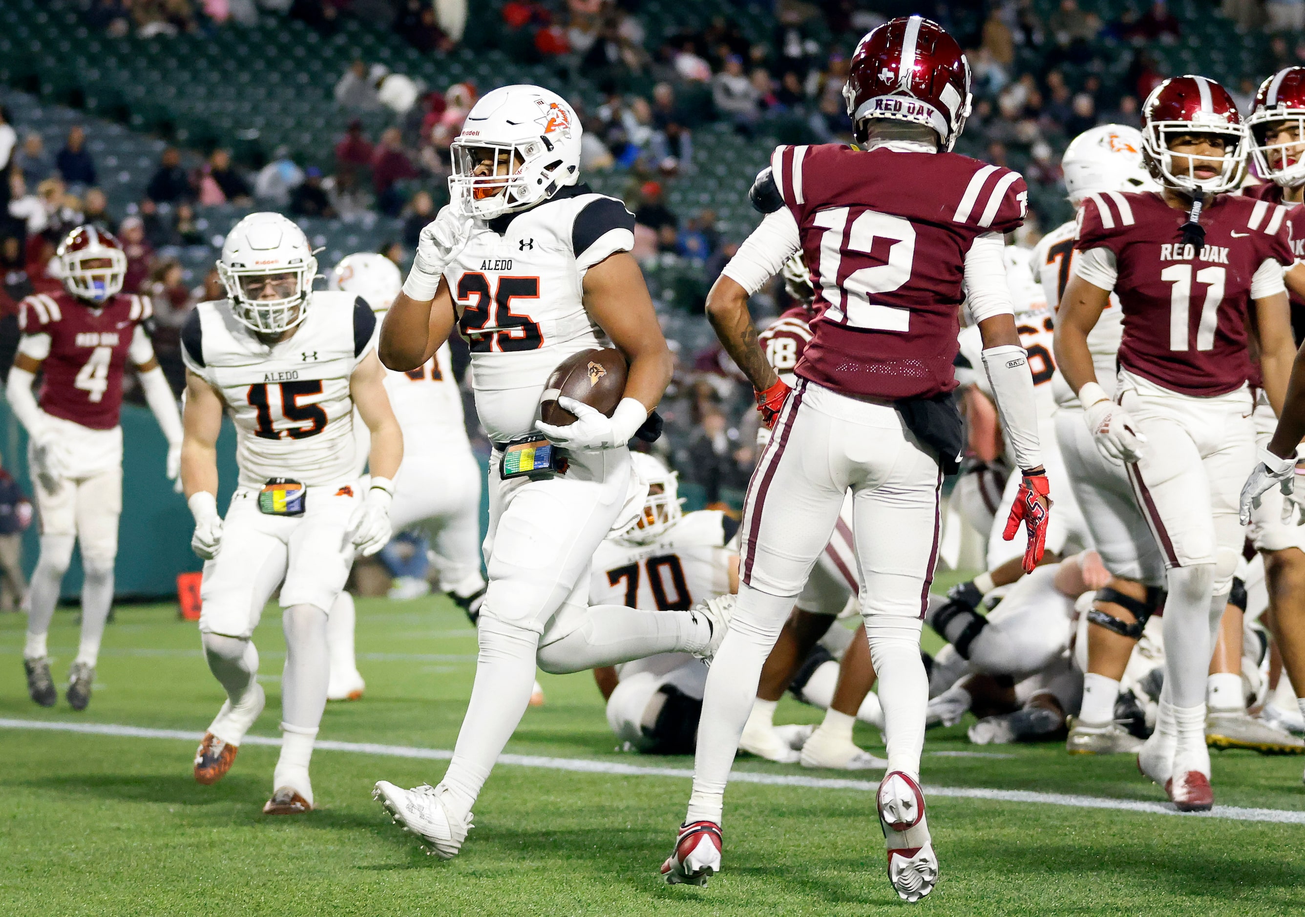 Aledo full back RJ Blake (25) signals to keep quiet as he crosses the goal line for a fourth...