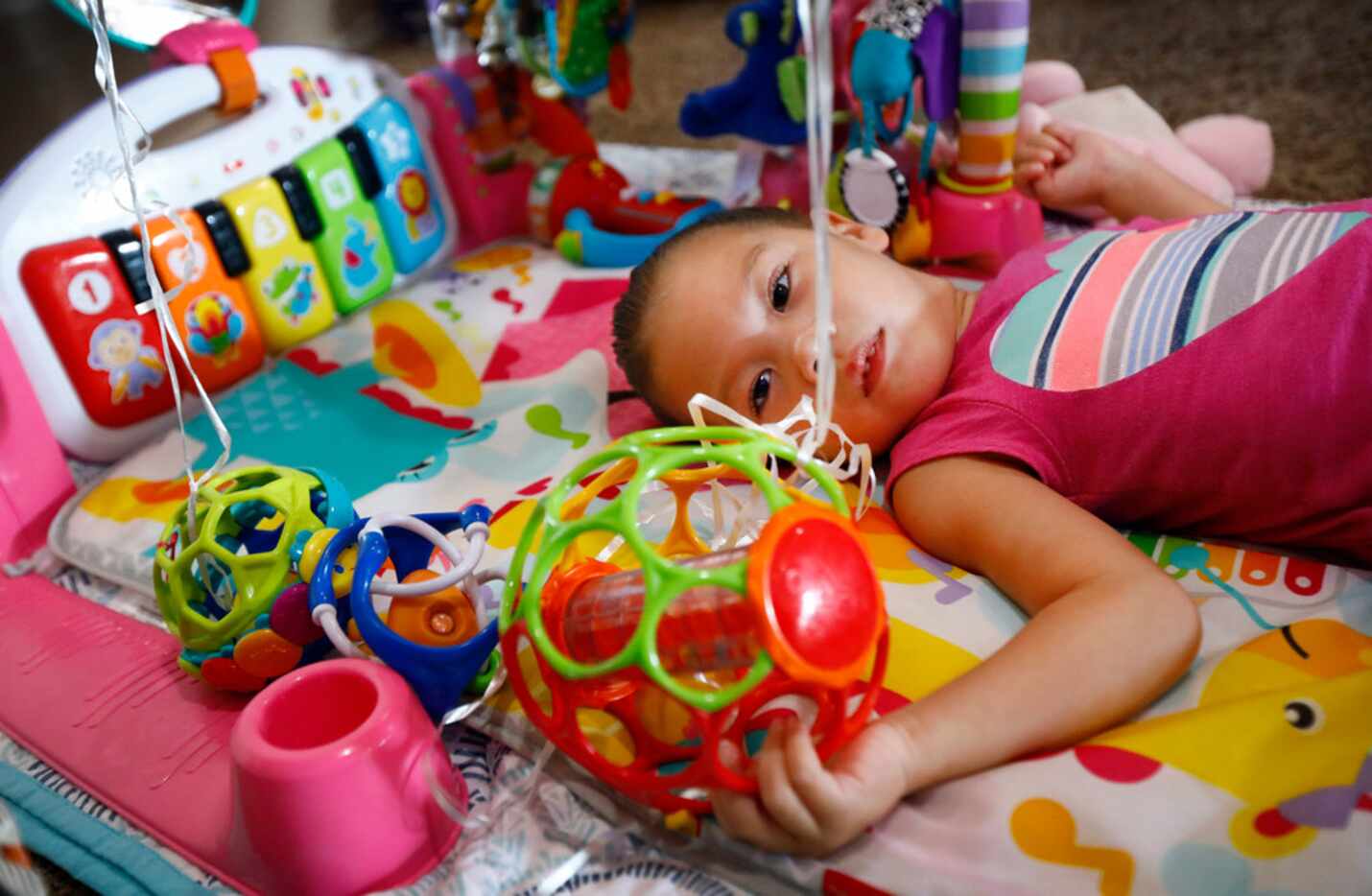 Annalynne Magallon, who has cerebral palsy, spends a lot of time on her back playing with...