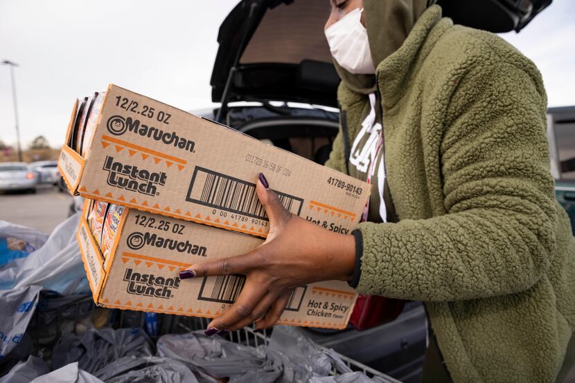 LaToya Brown loads boxes of ramen noodles into her car at the Walmart on Short Boulevard....