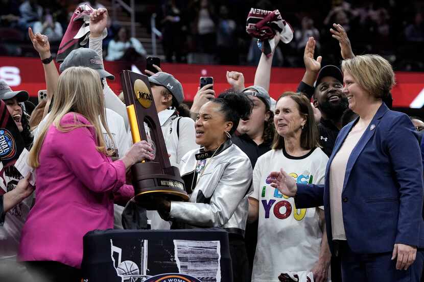 South Carolina head coach Dawn Staley, center, celebrates with the trophy after the Final...